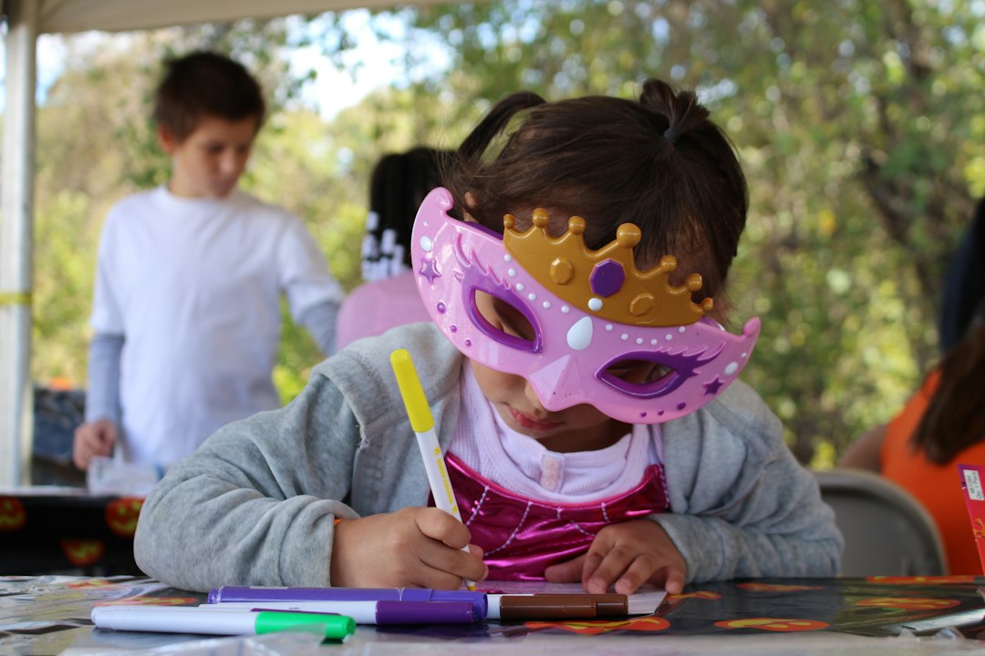 Enfant décorant un masque avec des feutres